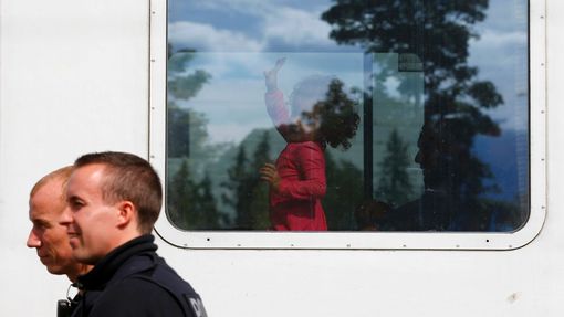 Policisté míjejí vlak s migranty v německém Freilassingu nedaleko hranic s Rakouskem.
