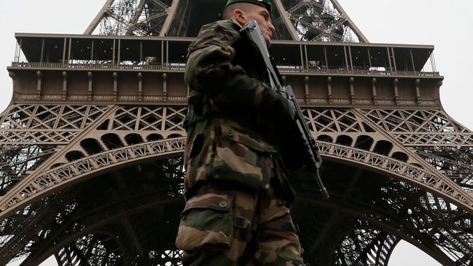 Voják hlídkuje před Eiffelovou věží.