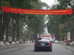 Limuzína premiéra Mirka Topolánka projíždí pod jedním z nápisů oslavujících jeho návštěvu