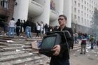 Demonstrant si odnáší televizi z vyrabovaného parlamentu v Kišiněvu.