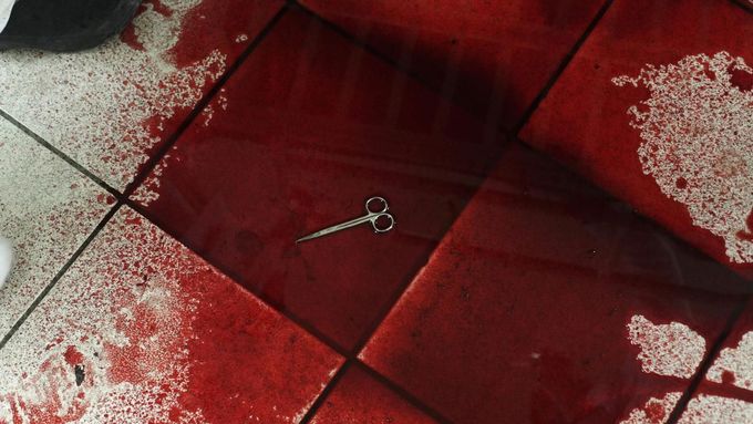 Lékařské nůžky zůstaly ležet v kaluži krve na podlaze na pohotovosti v nemocnici v San Pedro Sula 20. března 2013
