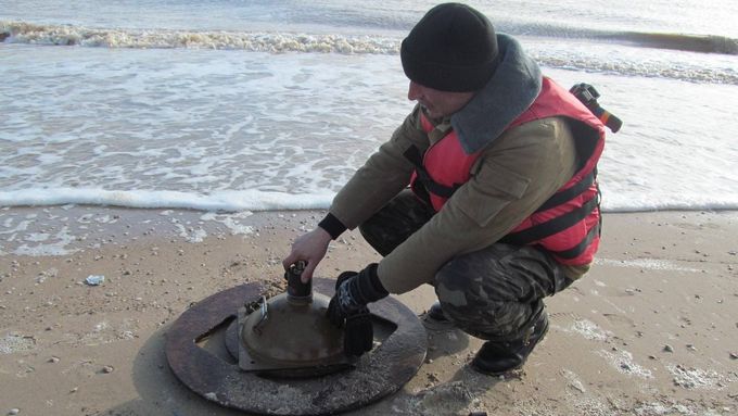 Ukrajinský voják pokládá minu na pobřeží Azovského moře.
