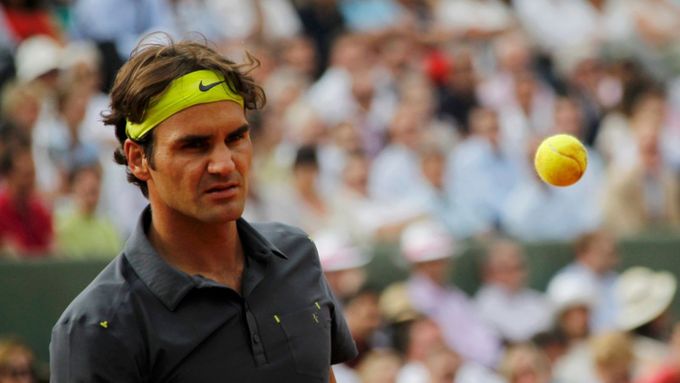 Švýcarský tenista Roger Federer se rozpinkává během utkání s Francouzem Nicolasem Mahutem ve 3. kole French Open 2012.