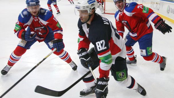 Hokejisté Lva Praha Jiří Novotný a Nathan Oystrick dohánějí Michala Vondrku v utkání KHL 2012/13 proti Slovanu Bratislava.