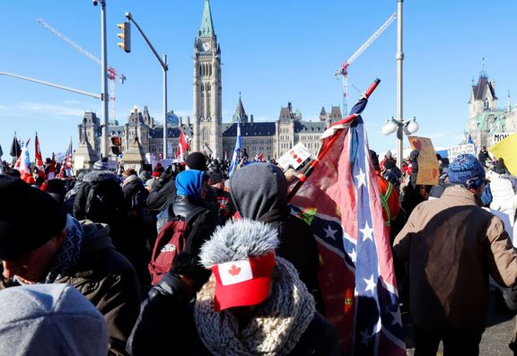 Demonstranti v Ottawě, jeden z nich drží konfederační vlajku.