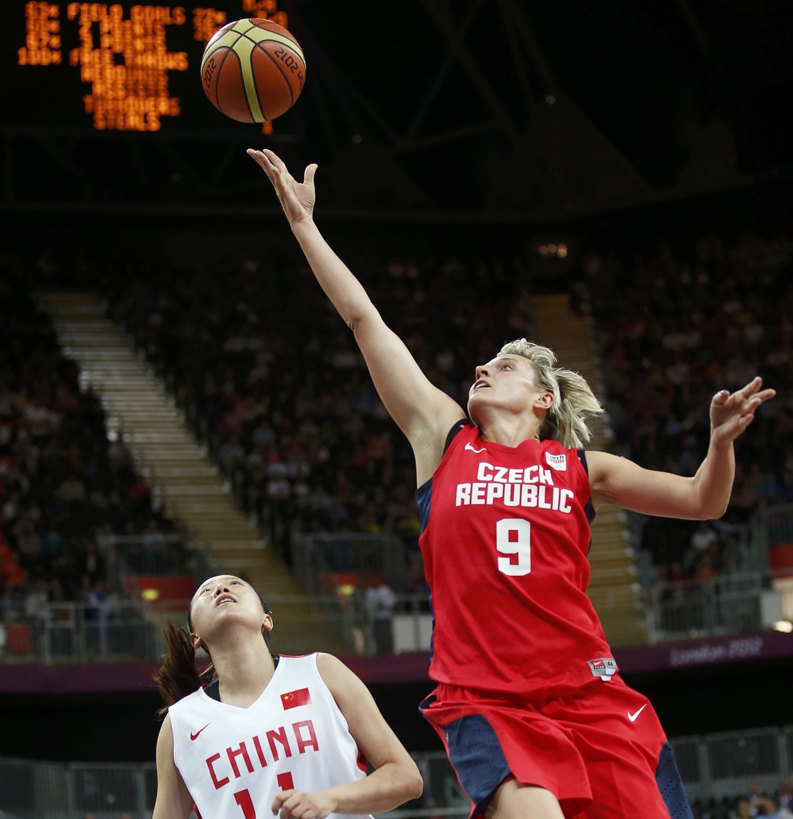 Česká basketbalistka Hana Horáková se snaží dostat míč do sítě přes Číňanku Zengju Maovou v turnaji OH 2012 v Londýně.