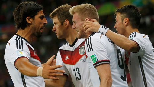 (L-R) Germany's Sami Khedira, Thomas Mueller and Mesut Ozil celebrate teammate Andre Schuerrle's (2nd R) goal against Algeria during extra time in their 2014 World Cup ro