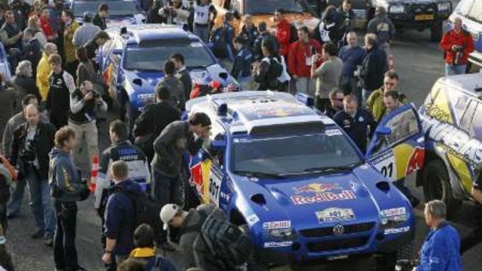 Čtyři modré tovární vozy Volkswagen Touareg se řadí v Lisabonu před technickou přejímkou na Rallye Dakar.
