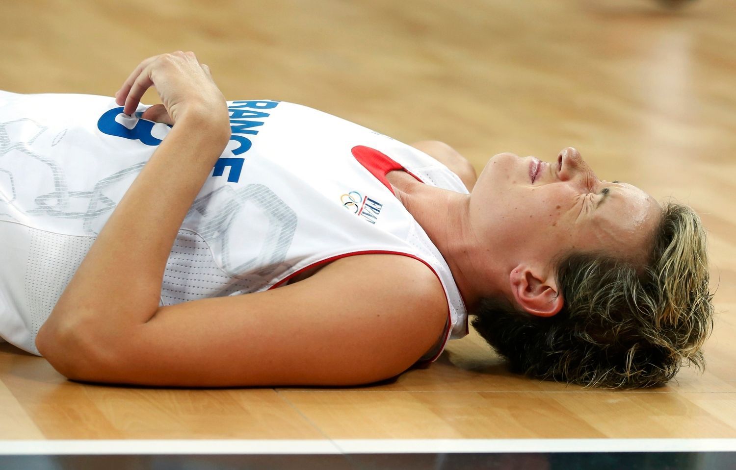 Francouzská basketbalistka Elodie Godinová leží po pádu v utkání s Českou republikou ve čtvrtfinále OH 2012 v Londýně.