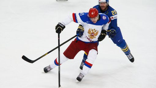 Russia's Yevgeni Malkin battles for the puck with Sweden's Joel Lundqvist (R) during the first period of their men's ice hockey World Championship semi-final game at Mins