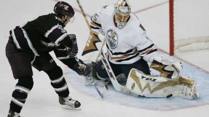 Brankář Edmontonu Dwayne Roloson zastavuje střelu útočníka Mighty Ducks Andy McDonalda ve druhém utkání finále Západní konference.