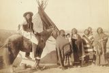 Skupina Lakotů (Siouxů). Vpravo ženy s dětmi, vlevo muž na koni. Vyfotografováno pravděpodobně poblíž rezervace Pine Ridge.