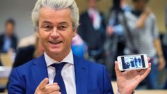 Dutch far-right Party for Freedom leader Geert Wilders shows the picture of the photographers he took with his cell phone prior to his trial in the courtroom in the courthouse in Schiphol