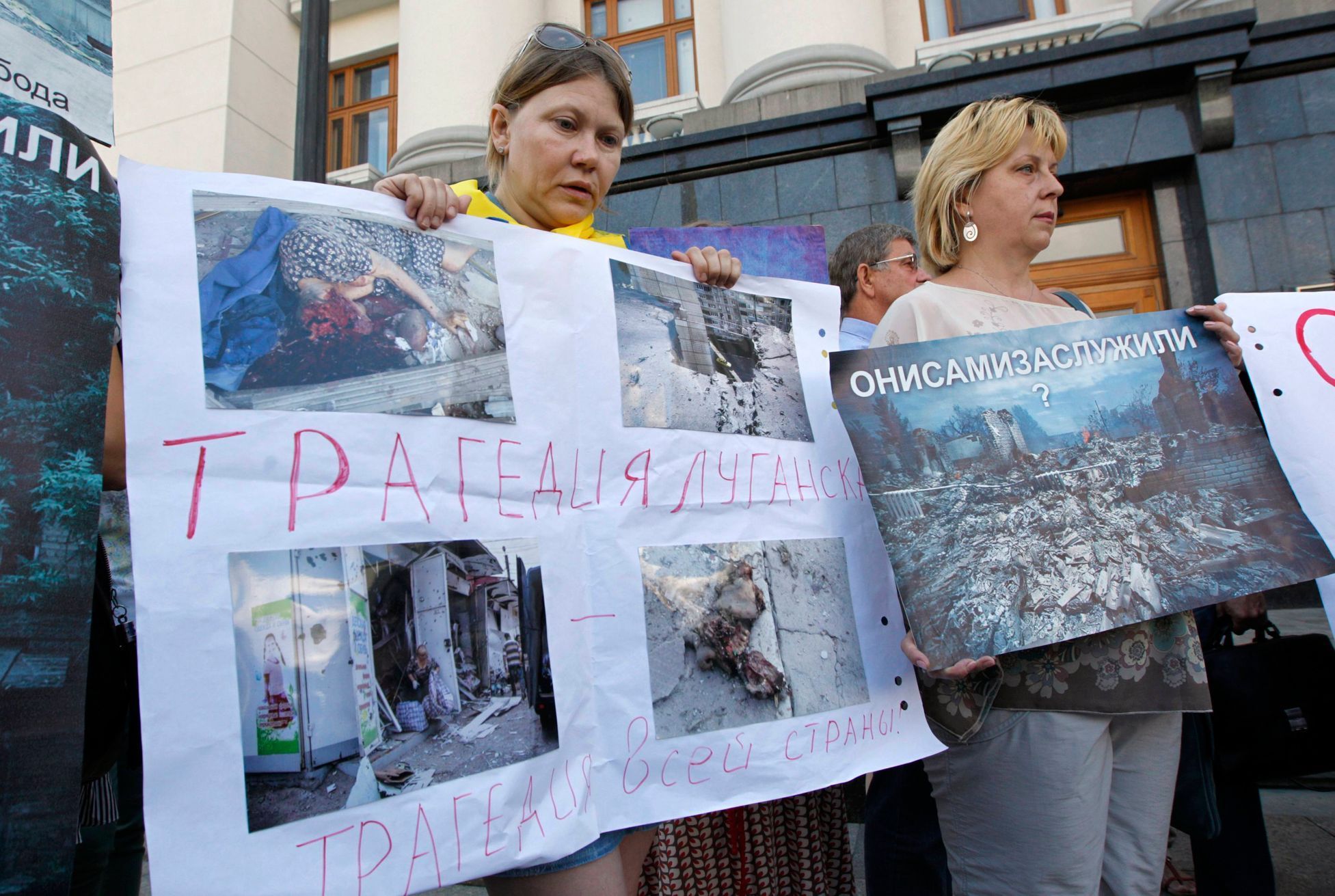 Uprchlice z Luhansku ukazují na demonstraci v Kyjevě, co se stalo s jejich domy.