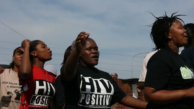 Dobrovolnice z organizace TAC utvořily kolečko a dostávají se do nálady zpěvem a tancem krátce předtím, než vyrazí na misi v townshipu Philippi.