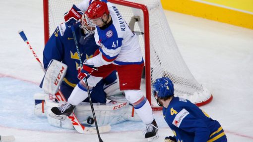 Sweden's goalie Anders Nilsson (L) saves in front of Russia's Nikolai Kulyomin in the first period of their men's ice hockey World Championship semi-final game at Minsk A