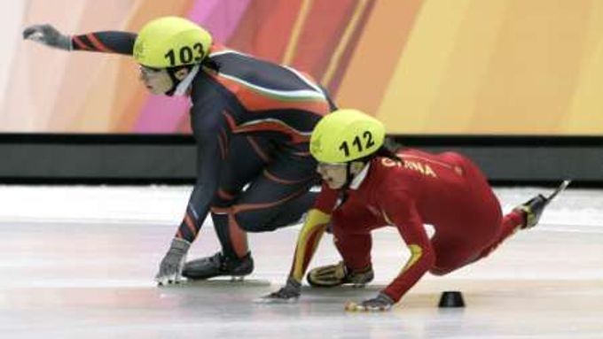 Číňaka Yangová padá po souboji s Maďarkou Erikou Huszarovou v shorttracku.