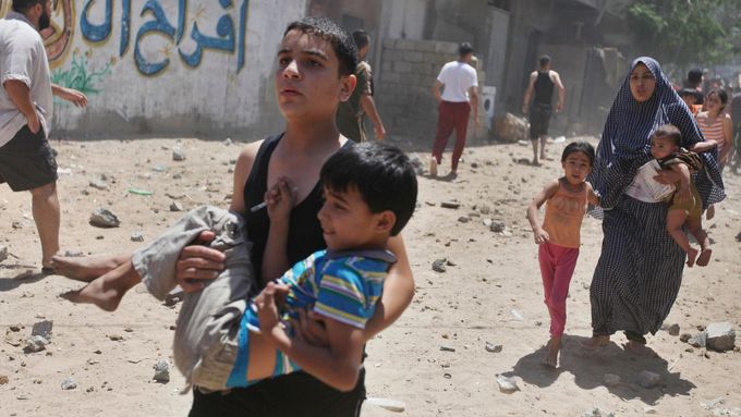 Palestinci utíkají poté, co na dům v Gaze podle policejních informací zaútočil Izrael.