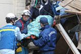 Záchranáři nesou na nosítkách z trosek vyproštěnou babičku Sumi Abe z Mijagi.