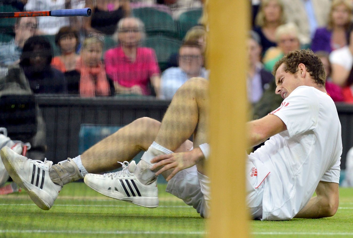 Britský tenista Andy Murray při pádu během utkání se Švýcarem Rogerem Federerem ve finále Wimbledonu 2012.