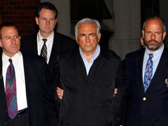 Šéf Mezinárodního měnového fondu Dominique Strauss-Kahn (uprostřed) je eskortován policií v New Yorku do vazby.