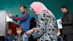Žena si prohlíží hlasovací lístek ve volební místnosti v jihoruském Stavropolu.