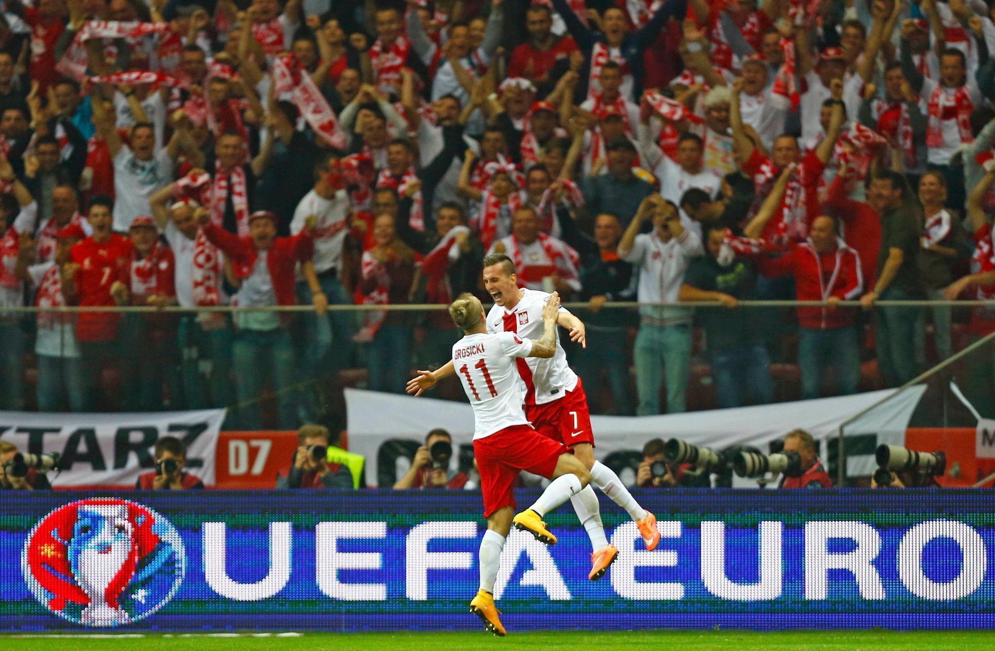Poland's Milik celebrates with his team mate Grosicki his goal against Germany during their Euro 2016 group D qualifying soccer match at the National stadium in Warsaw