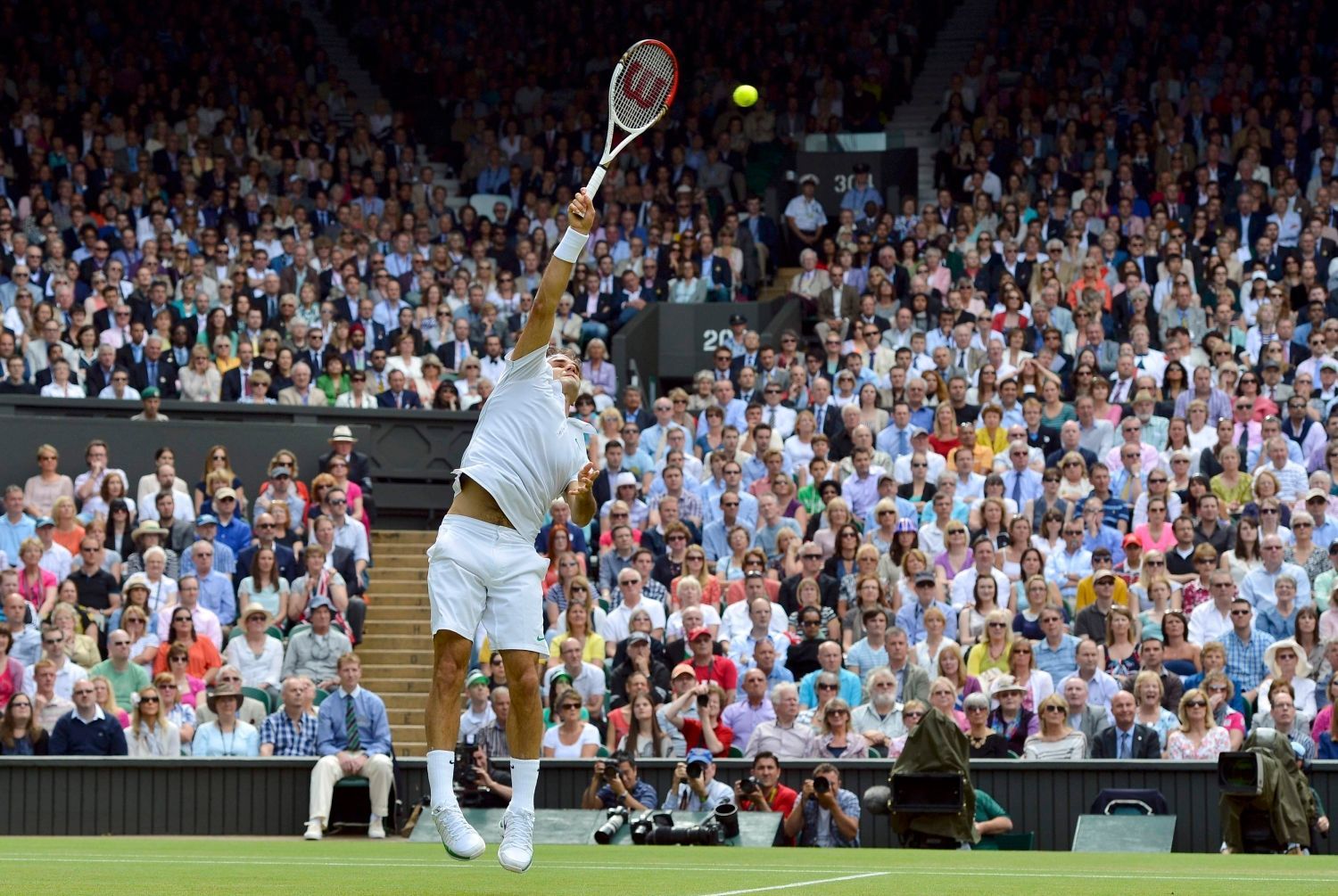 Švýcarský tenista Roger Federer podává na Brita Andyho Murrayho ve finále Wimbledonu 2012.