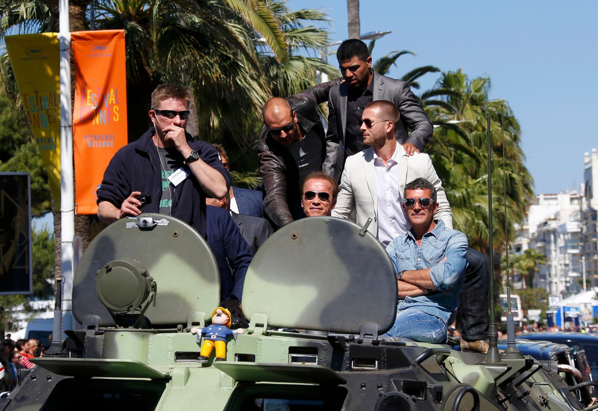 Cast members Victor Ortiz, Arnold Schwarzenegger, Victor Ortiz, Glen Powell and Antonio Banderas pose on a tank as they arrive on the Croisette to promote the film &quot;The Expendables 3&quot; during