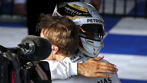 Mercedes F1 driver Nico Rosberg (R) is hugged by team mate Lewis Hamilton after winning the Australian Formula One Grand Prix in Melbourne