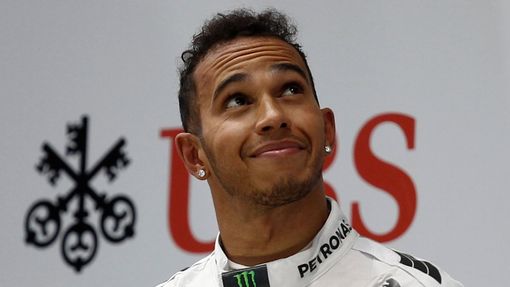 First-placed Mercedes Formula One driver Lewis Hamilton of Britain looks up as he stands on the winners' podium during the Chinese F1 Grand Prix at the Shanghai Internati