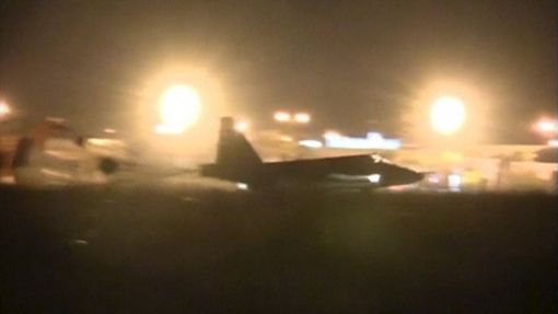 Ruský bombardér na letišti v Sýrii po náletu (fotografováno mobilním telefonem).