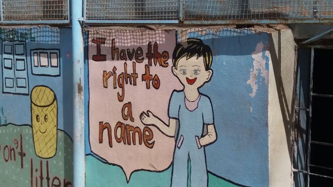 "Mám právo na své jméno." Kresba na zdi vybetonovaného školního dvorku.