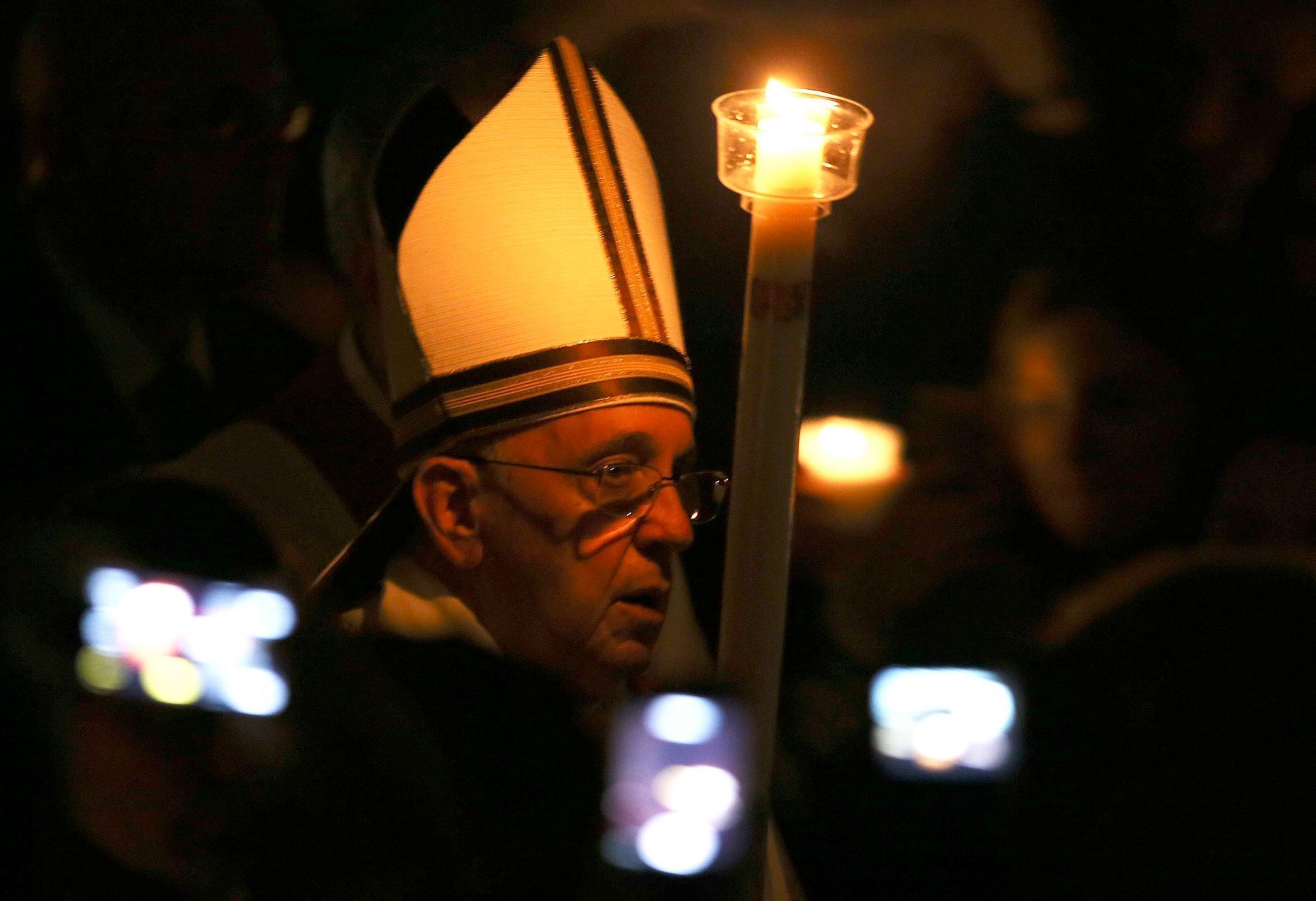 Pope Francis holds a candle as he leads a vigil mass during Easter celebrations at St. Peter's Basilica in the Vatican