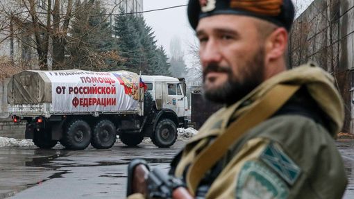 Proruský separatista hlídá v ulicích Makejevky, kterými právě projíždí ruský konvoj s humanitární pomocí.