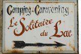 Cedule turistického kempu Le Solitaire du Lac v Savojských Alpách, kde byly nalezeny oběti záhadné vraždy.