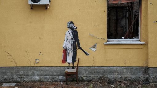 Žena v županu s natáčkami ve vlasech a v plynové masce s hasicím přístrojem, taktéž od Banksyho.