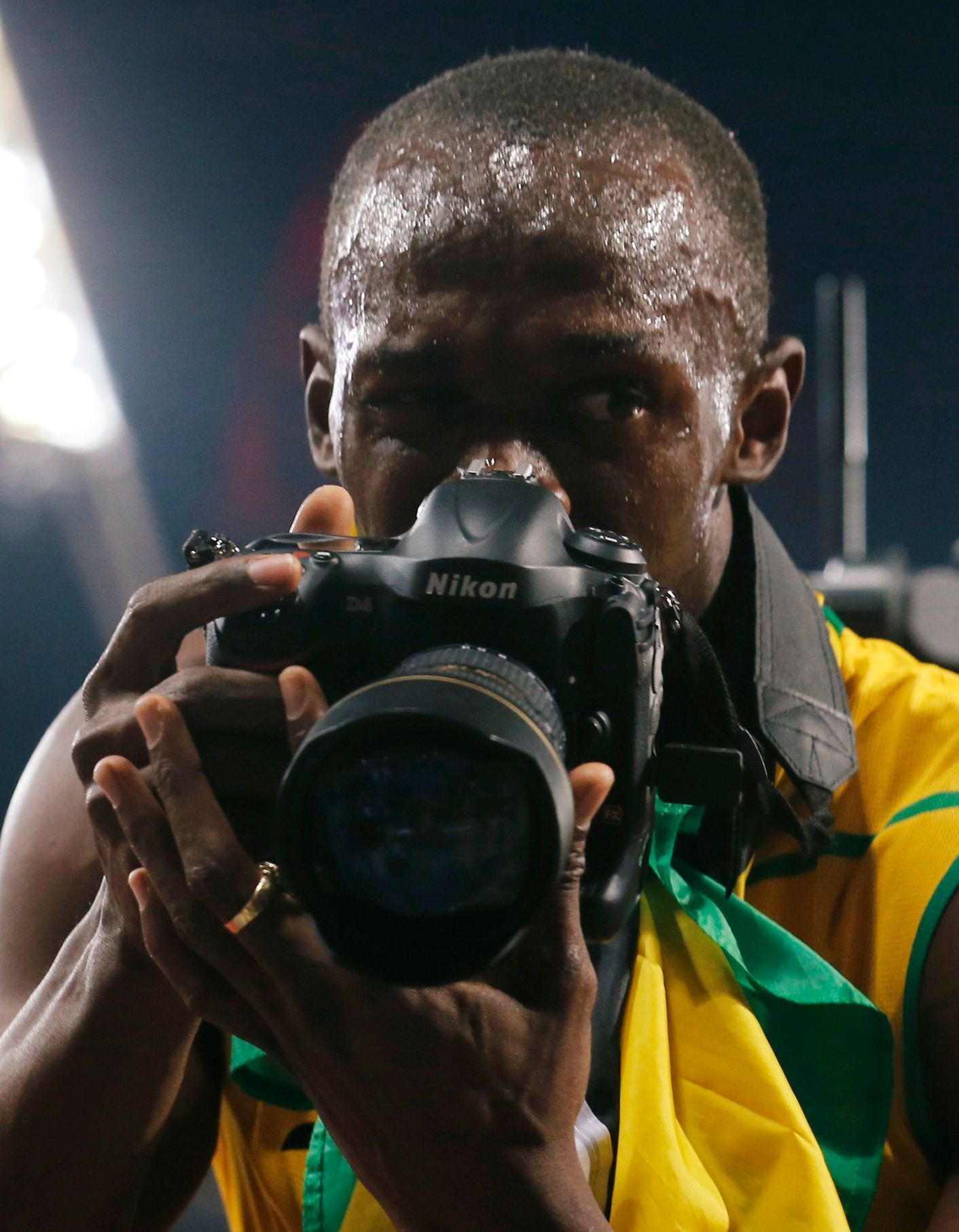 Usain Bolt si hraje na fotografa po vítězství v závodě na 200 metrů na OH 2012