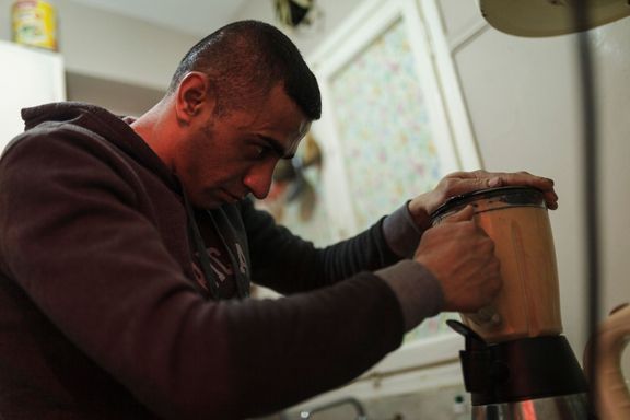 Ibrahim si před tréninkem připravuje proteinový nápoj.