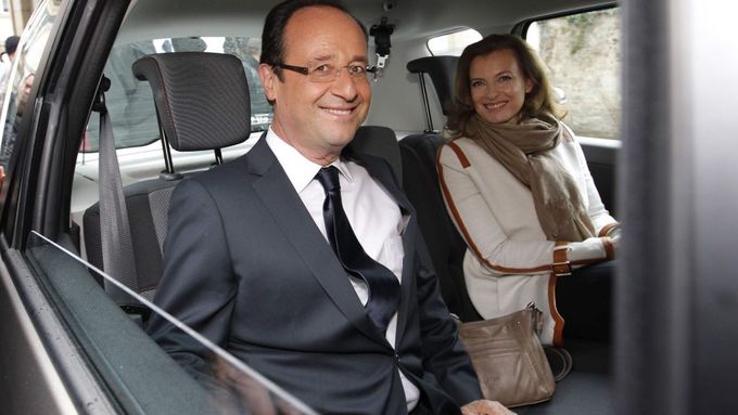 Hollande odjíždí se svojí partnerkou od volební místnosti.