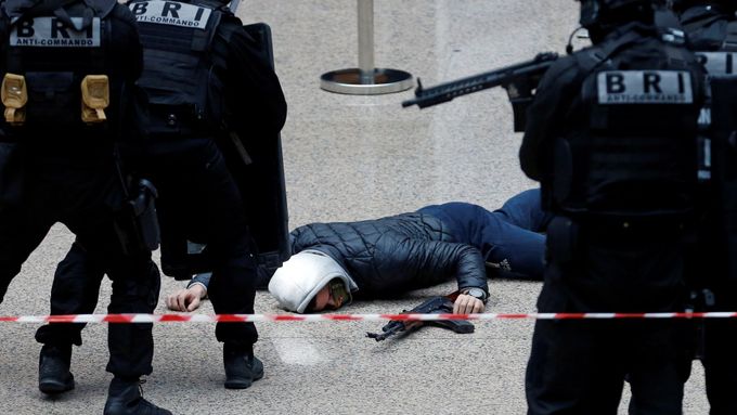 Příslušníci francouzských speciálních policejních jednotek zadržují ozbrojeného útočníka.