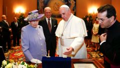 Pope Francis presents gift to Britain's Queen Elizabeth as Prince Philip looks on during a meeting at the Vatican