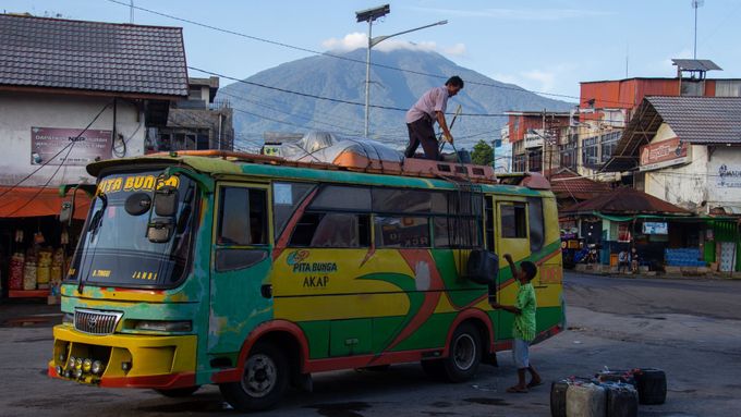 Krajina Sumatry je hornatá a seismicky nestabilní. Autobusový terminál v Bukittinggi (v pozadí hora Merapi), Sumatra, Indonésie.