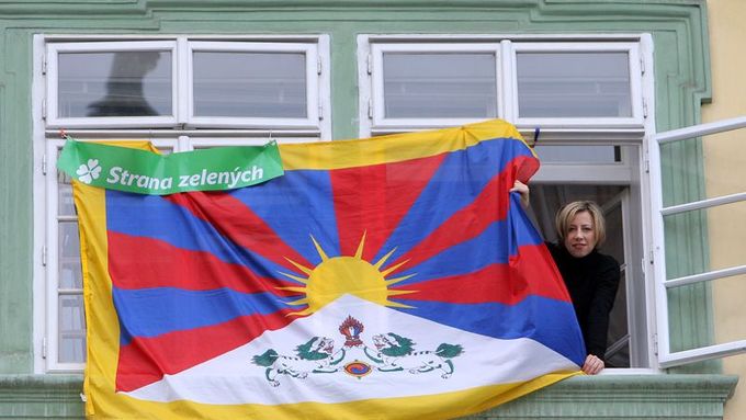 Poslankyně Kateřina Jacques v okně vedle tibetské vlajky, kterou poslanci Strany zelených vyvěsili na okna kanceláří poslaneckého klubu Sněmovny loni