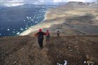Polárníci při návratu z terénního výzkumu na Bibby Hill, v pozadí cíl jejich cesty, Česká vědecká stanice J.G. Mendela, ostrov Jamese Rosse.