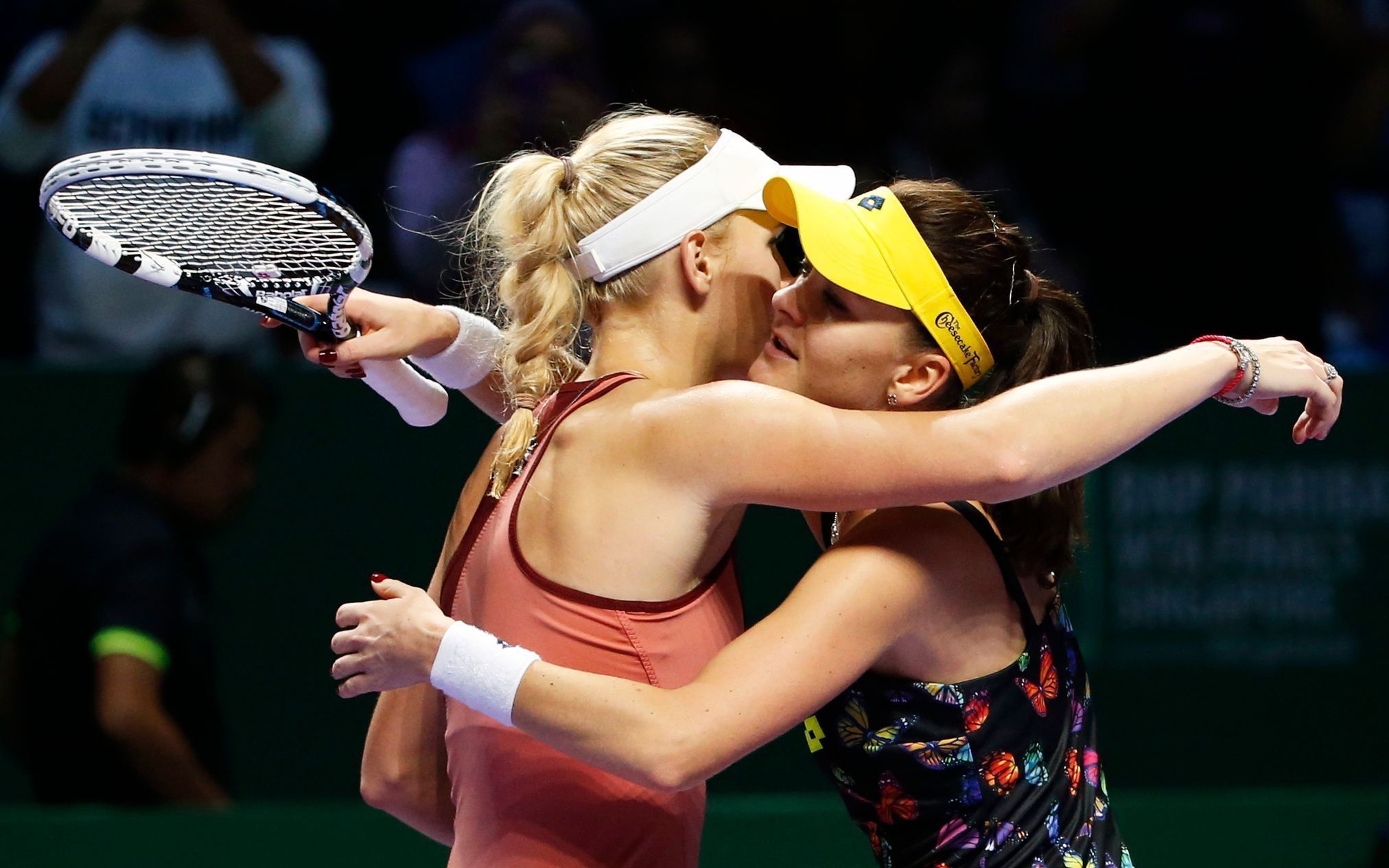 Caroline Wozniacki of Denmark is congratulated by Agnieszka Radwanska of Poland during WTA Finals singles tennis match at the Singapore Indoor Stadium