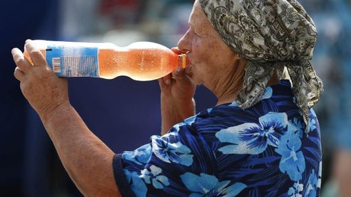 A woman drinks soda in central Donetsk June 25, 2012. Temperatures recently reached up to 35 degrees Celsius (95 degrees Fahrenheit) in eastern Ukraine. REUTERS/Yves Herman (UKRAINE - Tags: SOCIETY ENVIRONMENT) Published: Čer. 25, 2012, 2:31 odp.