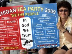 Stoupenkyně hnutí čajového dýchánku Ellie Melsová drží plakát, na němž inzeruje, v co věří Američané jako ona, a co prosazují "oni".