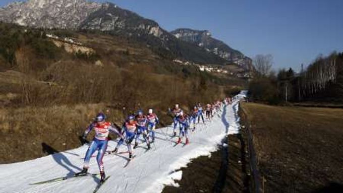 Běžkyně na lyžích šplhají do kopce při finálovém závodě Tour de Ski ve Val di Fiemme.