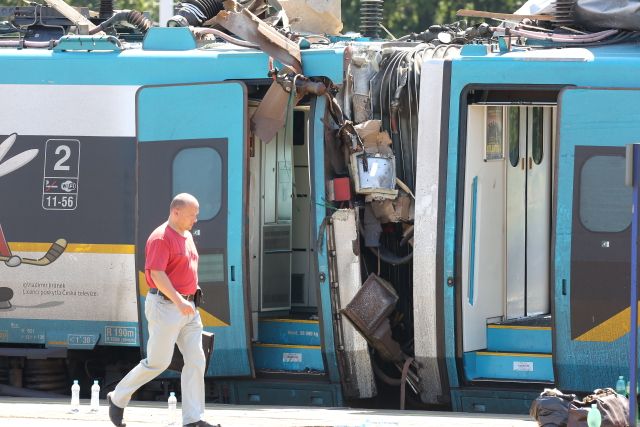 Zadní část vlaku stojí zhruba v polovině nástupiště. Je vidět, jak trosky kamionu, které s sebou pendolino táhlo, poničily konstrukci nástupiště. | Foto: ČTK